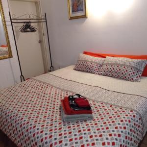 un letto con un cappello rosso sopra di Homestay at Julie's a Cairns