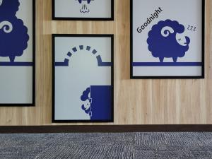 a group of framed pictures of sheep on a wall at Kokotel Hakodate in Hakodate