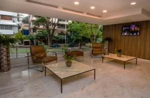 a lobby with chairs and tables in a building at Ramada by Wyndham Panama Via Argentina in Panama City