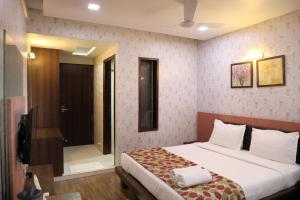 um quarto com uma cama e uma cabina de duche ao nível do chão em Hotel Pearls em Aurangabad