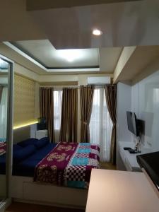 um quarto com uma cama e uma televisão em Apartemen Malioboro city by Ameliarooms em Yogyakarta