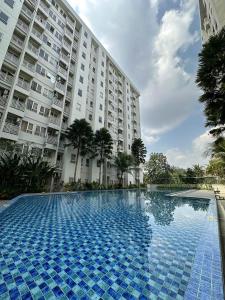 een groot zwembad voor een groot gebouw bij Apartemen Malioboro city by Ameliarooms in Yogyakarta
