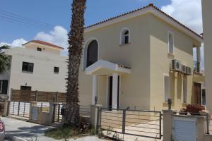a house with a palm tree in front of it at Villa Marina in Paphos