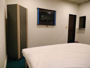 a bedroom with a bed and a flat screen tv at Hotel Royal Sweet in Lahore +16 photos