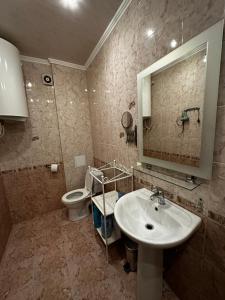 a bathroom with a sink and a toilet and a mirror at Apartment on Agrba in Pizunda