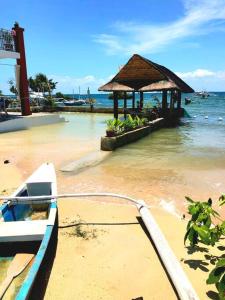 a boat tied to a dock with a building in the water at PRIVATE COLLECTION 贅沢 Jade's Beach Villa 별장 Cebu-Olango An exclusive private beach secret in Lapu Lapu City