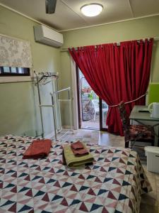 una camera con letto e tenda rossa di Homestay at Julie's a Cairns
