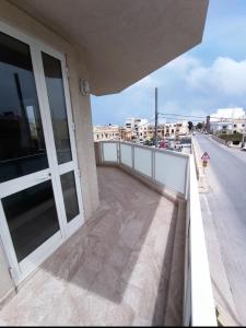 a balcony of a building with a view of a street at "Joseph 2" Stylish corner flat with open views, just 5km from the beach in Siġġiewi