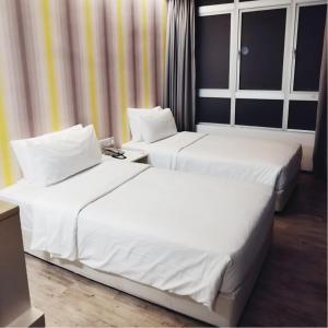 two beds in a hotel room with white sheets at Room in Genting Highland in Genting Highlands