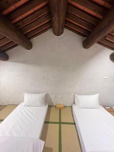 Postel nebo postele na pokoji v ubytování First Floor Inn Kinmen