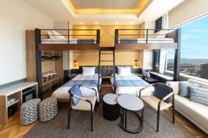 a bedroom with two bunk beds and a couch at AQA Hotel Premium in Saku