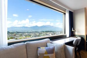 um quarto com uma grande janela com vista para a cidade em AQA Hotel Premium em Saku