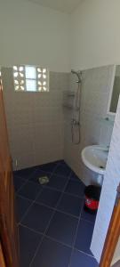 La salle de bains est pourvue de carrelage bleu et d'un lavabo. dans l'établissement appartement Villa Nancy, à Toamasina