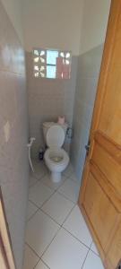 a bathroom with a toilet and a window at appartement Villa Nancy in Toamasina