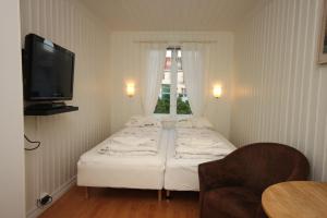 a small room with a bed and a television at Apartment Old Town Skudeneshavn in Skudeneshavn