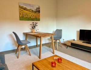 a living room with a wooden table and two chairs at Appartement Am Weinberg in Radebeul