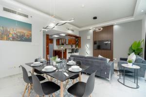 Marina Yacht Club Views - 3BR Modern Furnished في دبي: غرفة طعام وغرفة معيشة مع طاولة وكراسي