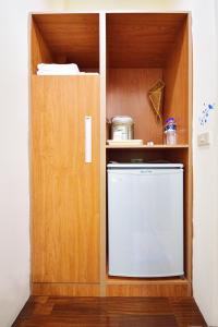 a kitchen with a refrigerator in a wooden cabinet at Chin Shan B&B in Guanshan