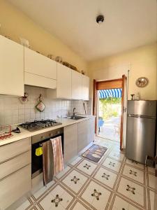 una cucina con armadi bianchi e piano cottura di Casa vacanza Salento, Santa Maria al Bagno a Galatone