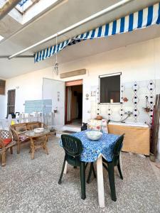 ein Wohnzimmer mit Tisch und Stühlen und einem Fernseher in der Unterkunft Casa vacanza Salento, Santa Maria al Bagno in Galatone