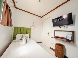 a bedroom with a bed and a flat screen tv at La Choeben Suites in Calbayog