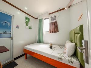 a small bedroom with a bed and a window at La Choeben Suites in Calbayog