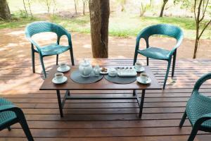 a table and chairs on a wooden deck at Life of Leisure Wilpattu in Pahala Maragahawewa