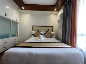 1 dormitorio con 1 cama grande y ventana grande en Rinann's Staycation Mesatierra Condotel Davao, en Davao City