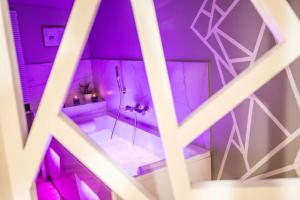 Cette chambre violette comprend une salle de bains pourvue d'une douche. dans l'établissement La Sublime Love House, à Briey