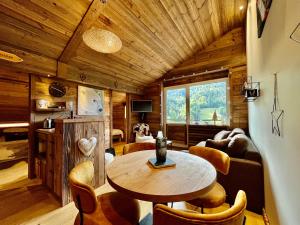 a living room with a table and chairs in a cabin at Appartement cosy vue montagne in La Clusaz