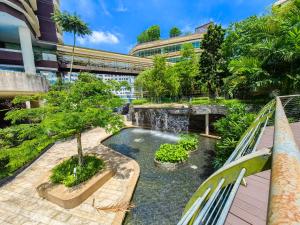 a garden with a waterfall and a pool at Afiniti Theme Suite by Nest Home【LEGOLAND】 in Nusajaya