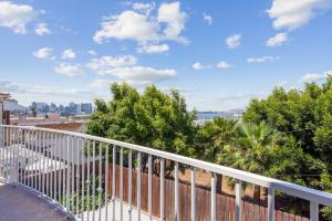 uma varanda com um corrimão branco e árvores em Charming Retreat on West Quince Street condo em San Diego