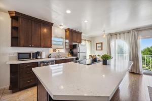 a kitchen with a white counter top and a large window at Charming Retreat on West Quince Street condo in San Diego