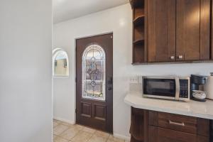 a kitchen with a microwave and a door at Charming Retreat on West Quince Street condo in San Diego