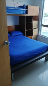 1 dormitorio con 1 litera con sábanas azules en Lujoso Condominio Frente al Mar en Tonsupa, Ecuador, en Tonsupa