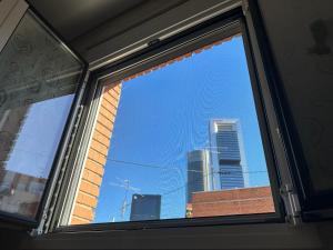 a window with a view of a city skyline at Habitación New York - 5 Torres in Madrid