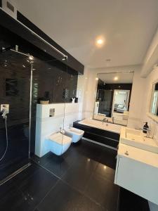 ティヒにあるRegina Luxury Apartamentのバスルーム(シンク2台、シャワー、バスタブ付)