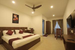 a bedroom with a large bed with a ceiling fan at Hotel Dream Suite, Kattappana in Kattappana