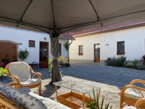 patio con sedie, tavolo e ombrellone di Kis-Duna Vendégház a Dunabogdány