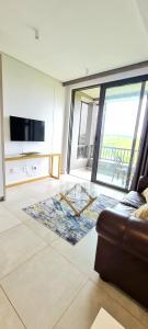 a living room with a couch and a large window at Zimbali Lakes Boulevard Suites in Ballito