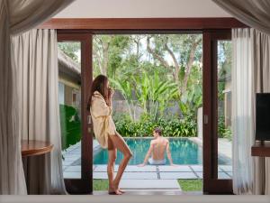 a woman talking on a cell phone in front of a house at The One Boutique Villa in Seminyak