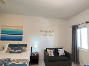 - une chambre avec un lit, un canapé et une fenêtre dans l'établissement Lovely Apartment #3 in Venetian Site, à Turtle Cove