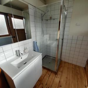 a white bathroom with a sink and a shower at Beachouse in Lock Sport
