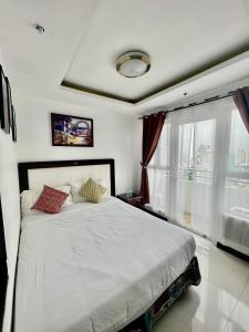 マニラにあるBirch Tower Malate Suitesのベッドルーム(白いベッド1台、窓付)