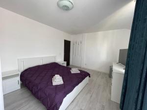 a bedroom with a purple bed and a television at EVA's Rooms in Târgu-Mureş