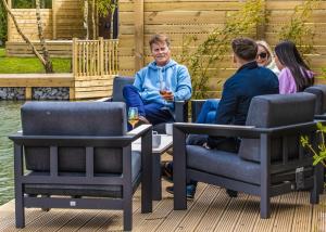 un grupo de personas sentadas alrededor de una mesa y sillas en Noahs Retreat en Laceby