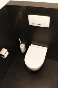 a bathroom with a white toilet in a black wall at Haus Schröcker in Gaschurn