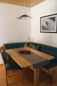 a dining room table and a blue couch with a wooden table at Haus Schröcker in Gaschurn