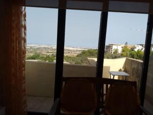 einen Balkon mit Aussicht, 2 Stühlen und einem Tisch in der Unterkunft Terraced house with stunning view close to Mdina in Rabat