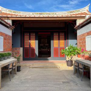 a building with tables and chairs in front of it at 壹樓文旅 in Jinhu